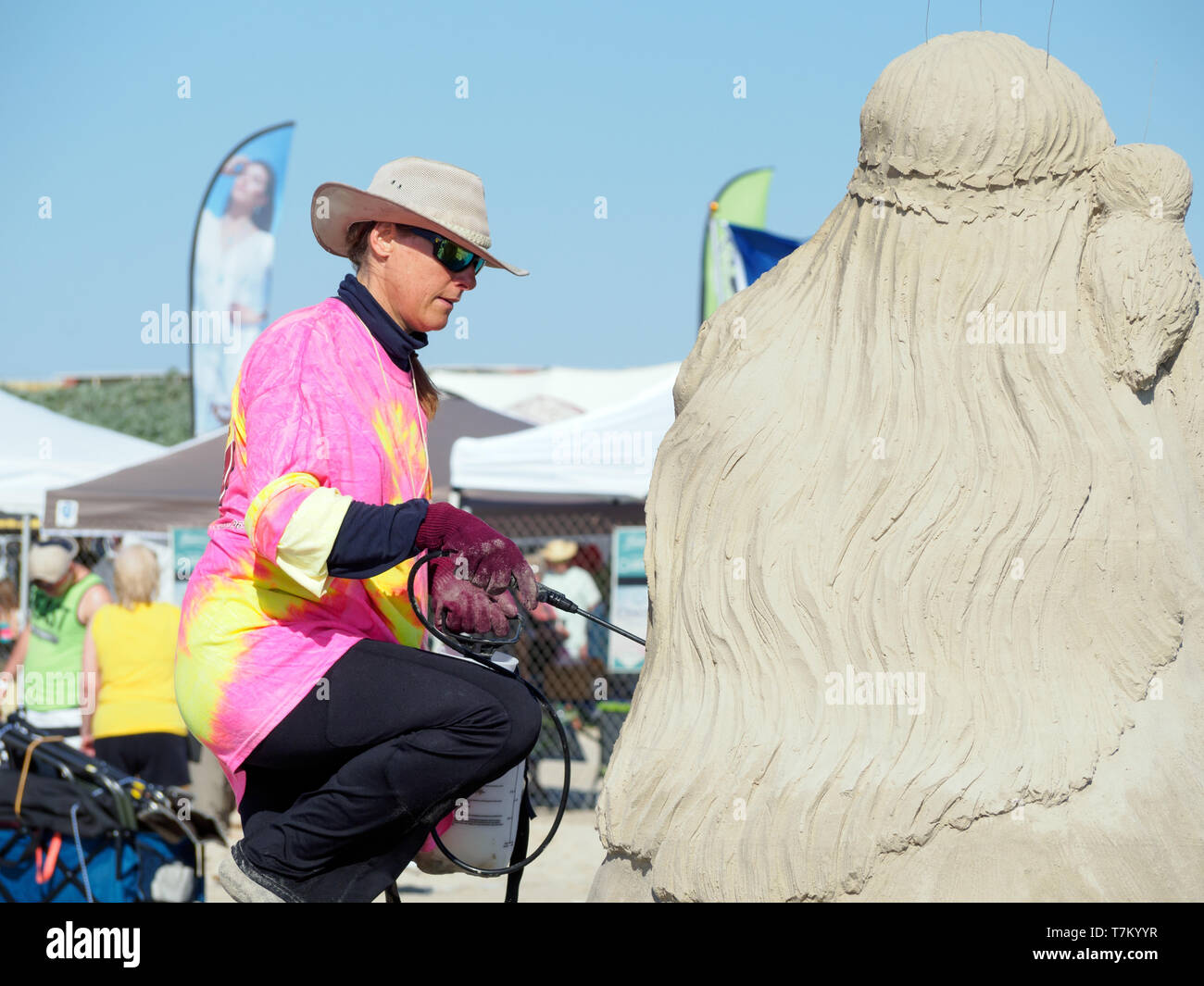 Remy Hoggard pulvérise la solution mouillante sur sa 3ème Place & People's Choice award winning sculpture 'Sofia' Sandfest, Texas, 2019 Port Aransas, Texas USA. Banque D'Images