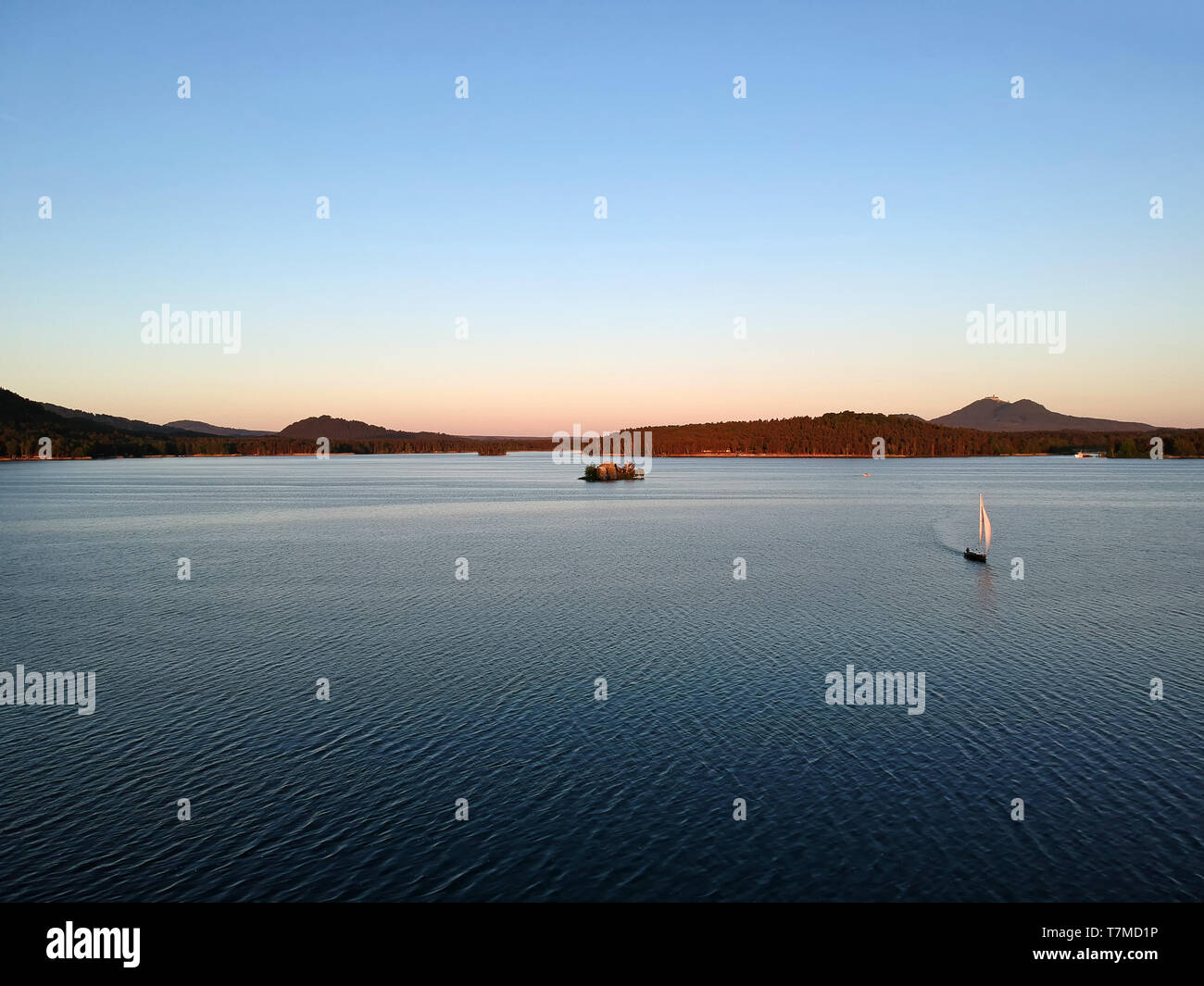 Location de bateaux sur le lac Machovo dans l'Kokorinsko. Derrière lui, c'est château Bezdez. Il y a le coucher du soleil. Banque D'Images