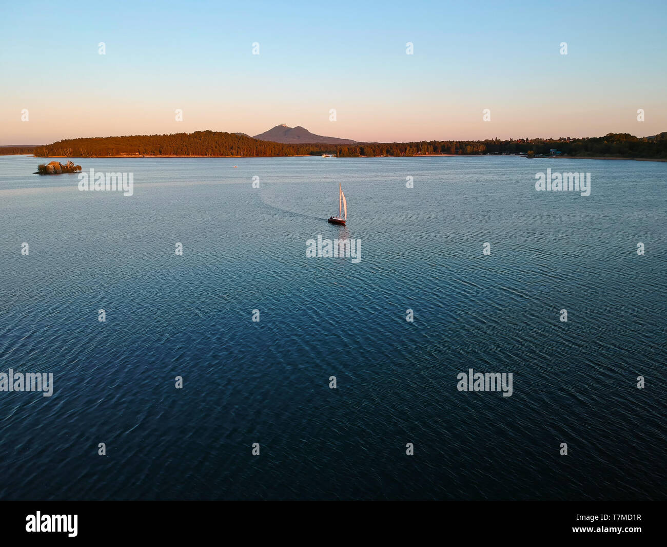 Location de bateaux sur le lac Machovo dans l'Kokorinsko. Derrière lui, c'est château Bezdez. Il y a le coucher du soleil. Banque D'Images