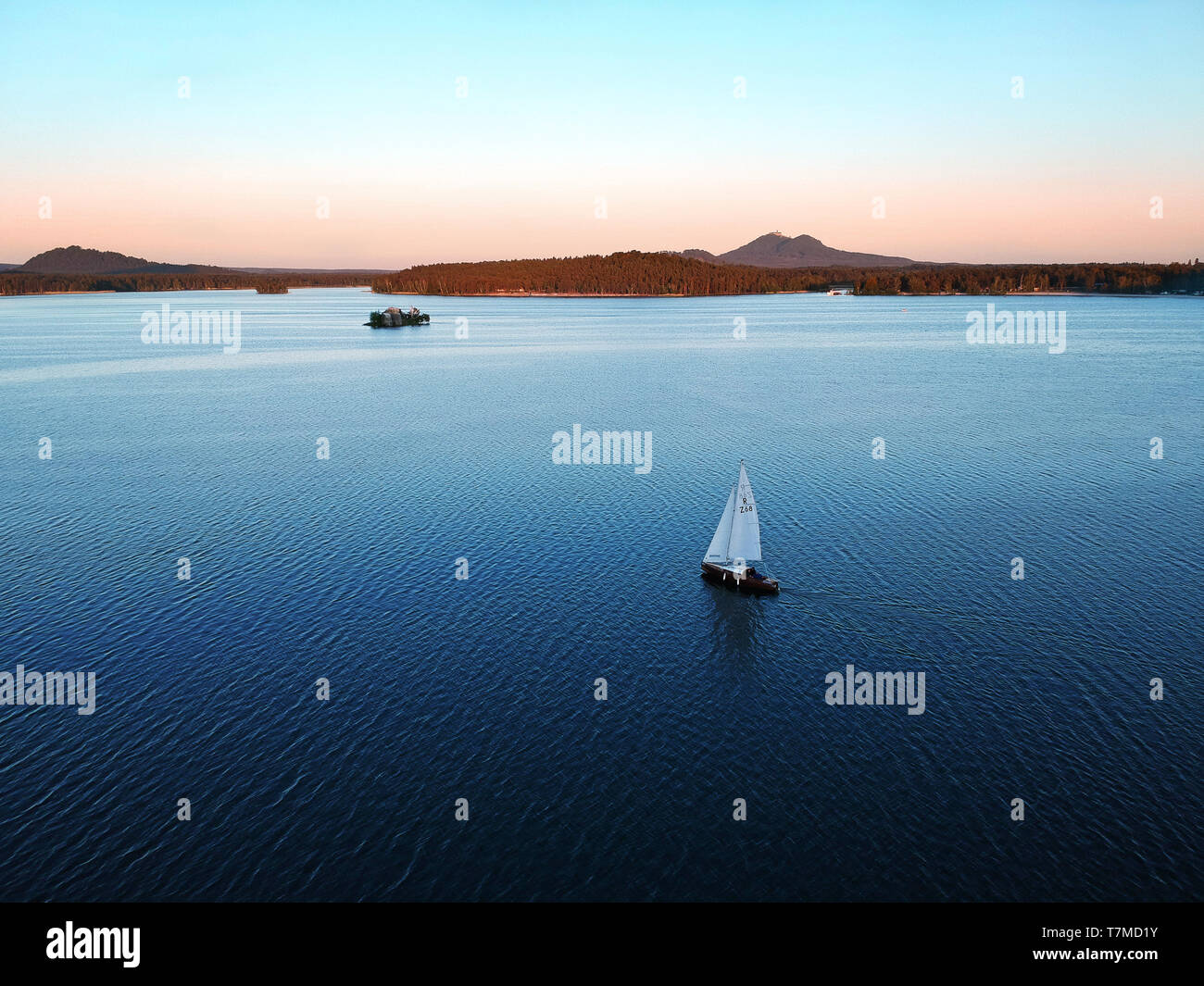 Location de bateaux sur le lac Machovo dans l'Kokorinsko. Derrière lui, c'est château Bezdez. Il y a le coucher du soleil. Banque D'Images