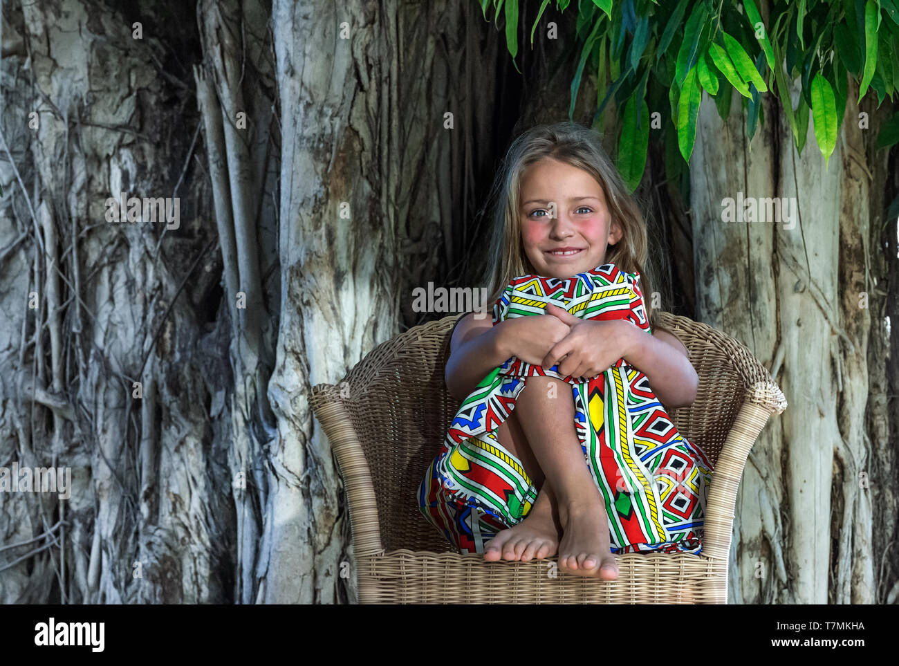 Peu de belle fille au fond d'arbres tropicaux. Portrait of cute child prêt pour des vacances tropicales. Banque D'Images