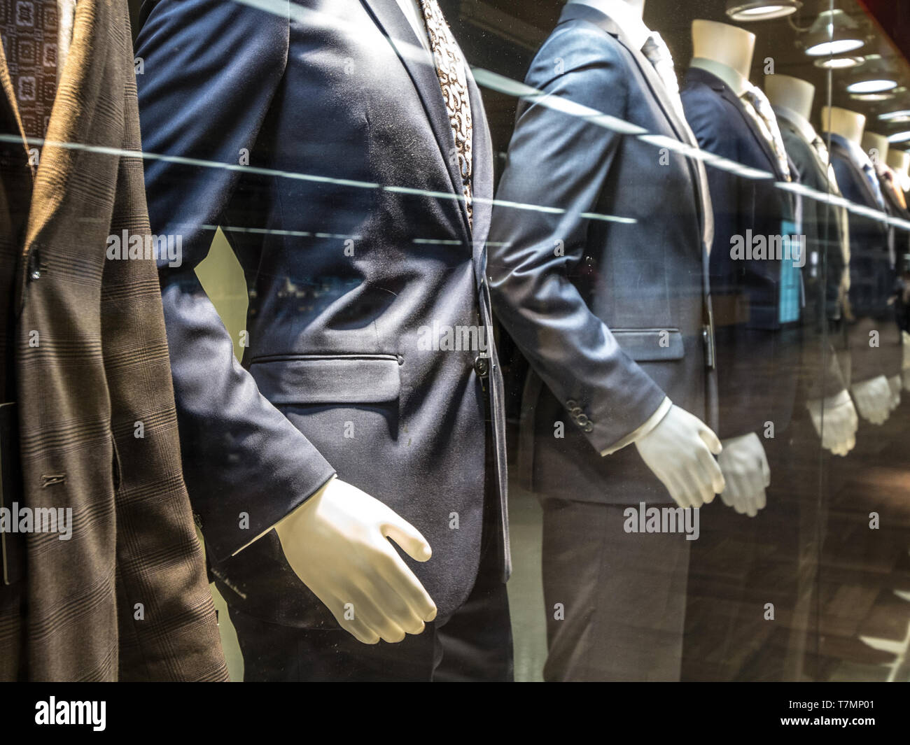 Costumes hommes, avec les chemises, cravates, pantalons et vestes bleu sur l'affichage sur des mannequins en face d'un magasin sur mesure, sur une fenêtre. Il est l'un des principaux garme formel Banque D'Images