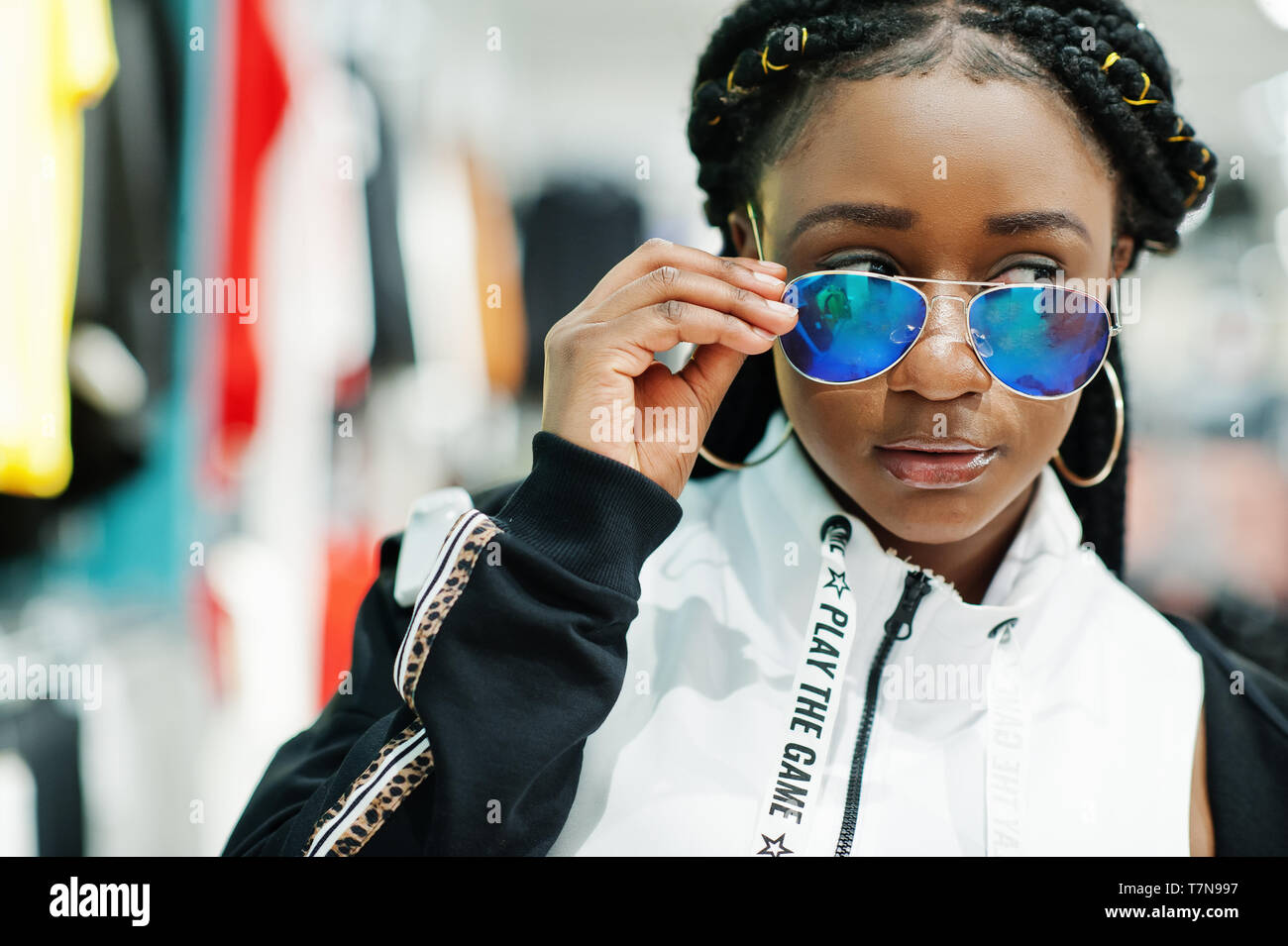 Afican femmes américaines en survêtements et lunettes de shopping au centre commercial de sport. Sport store thème. Banque D'Images