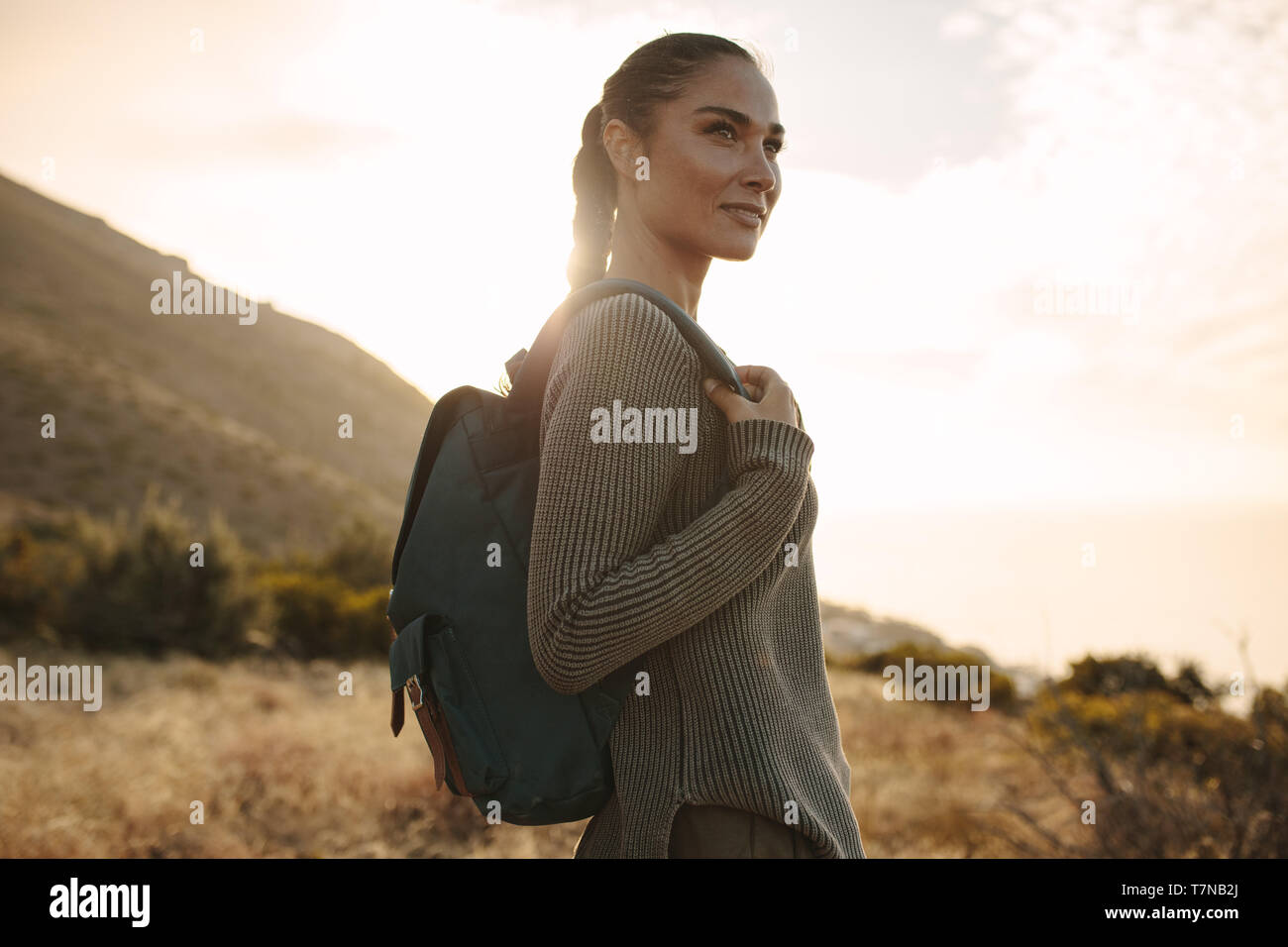 Femme marche sur une colline chemin avec un sac à dos. Pull femme portant un sac à dos et sur la randonnée. Banque D'Images