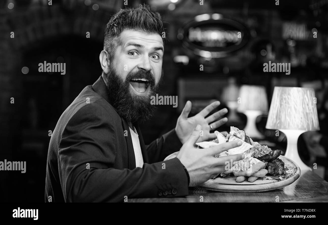 Woman costume formel s'asseoir à comptoir bar. L'homme a reçu de pommes de terre frites repas avec viande et poisson, lavash. Il méritent de délicieux repas. Profitez de repas. Des calories. Vous pourrez vous détendre après une dure journée de travail. Banque D'Images
