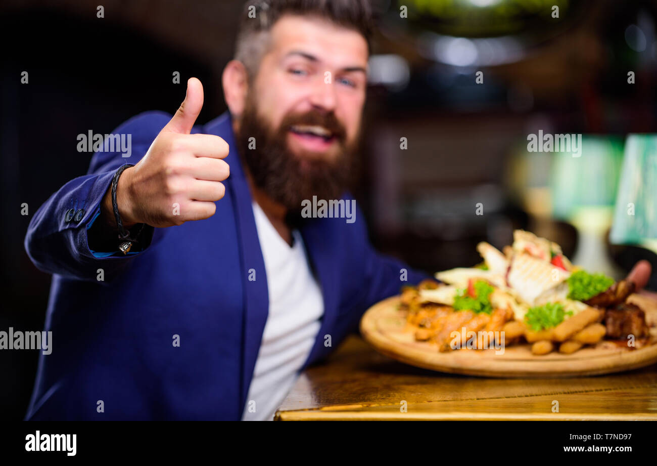 Vous pourrez vous détendre après une dure journée. La nourriture délicieuse. Woman costume formel s'asseoir au restaurant. L'homme a reçu de pommes de terre frites repas avec les bâtonnets de poisson viande. Il méritent de délicieux repas. Profitez de votre repas. Des calories. Banque D'Images