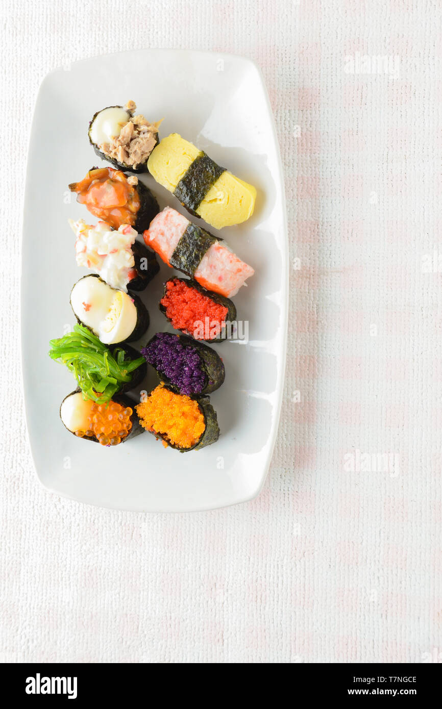 Sushi sur plaque blanche, thon, saumon, loup de mer, crevettes, oeufs sucrés sushi, cuisine japonaise Banque D'Images