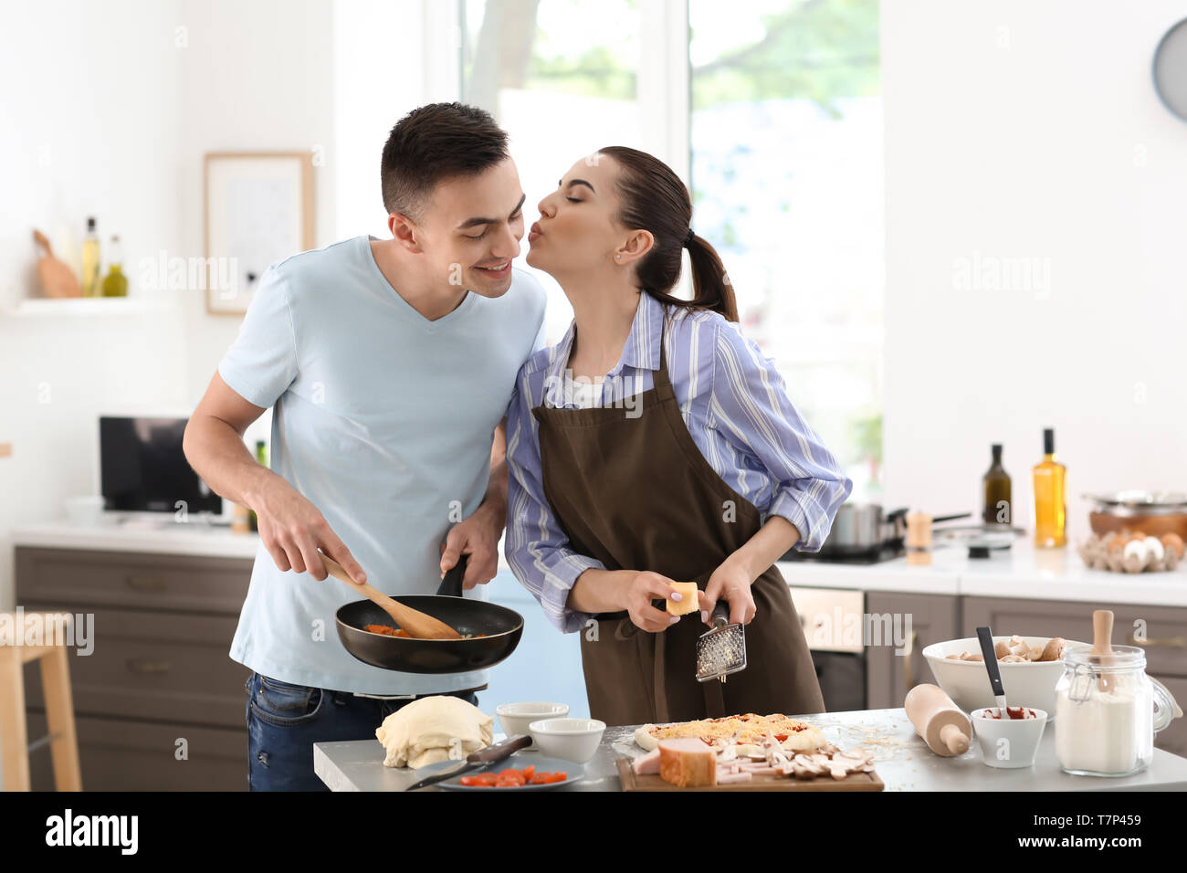 Jeune couple cooking together in kitchen Banque D'Images