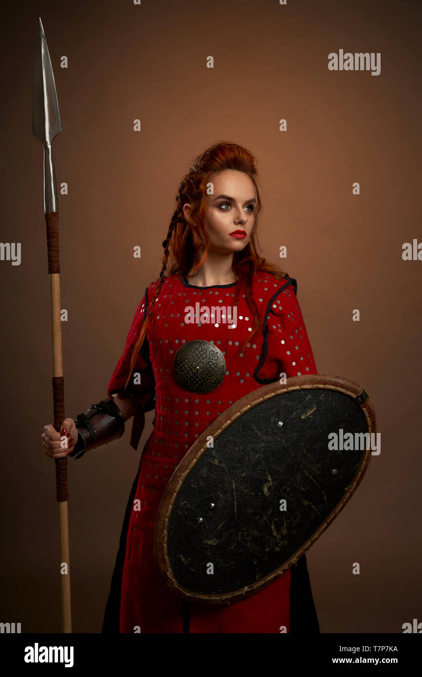 Femme Guerriere Determinee En Gardant La Lance Et Le Bouclier Et Le Posant Sur L Isolent En Studio Jolie Femme Courageuse A Cote Pendant Les Combats Notion De Puissance Et De Bataille Photo