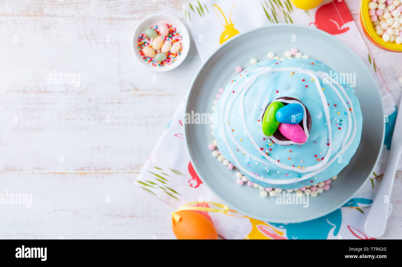 Gâteau de Pâques avec des œufs colorés. Fond en bois blanc. Vue d'en haut. Copier l'espace. Banque D'Images