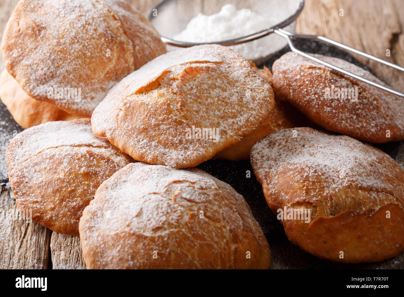 Frite traditionnelle Bunuelos saupoudrée de sucre en poudre sur la table horizontale. Banque D'Images