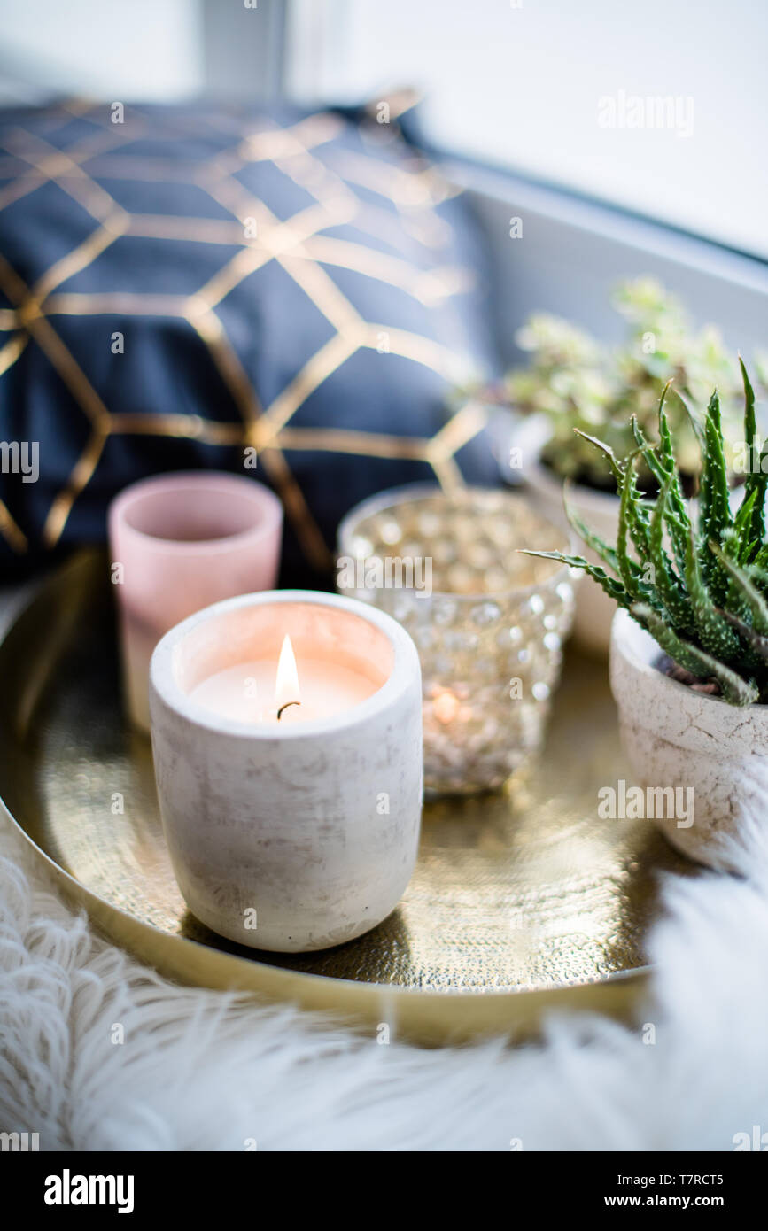 Du vrai confortable décoration maison, brûler des bougies sur le plateau  d'or avec oreiller sur la fausse fourrure blanche on windowsill Photo Stock  - Alamy