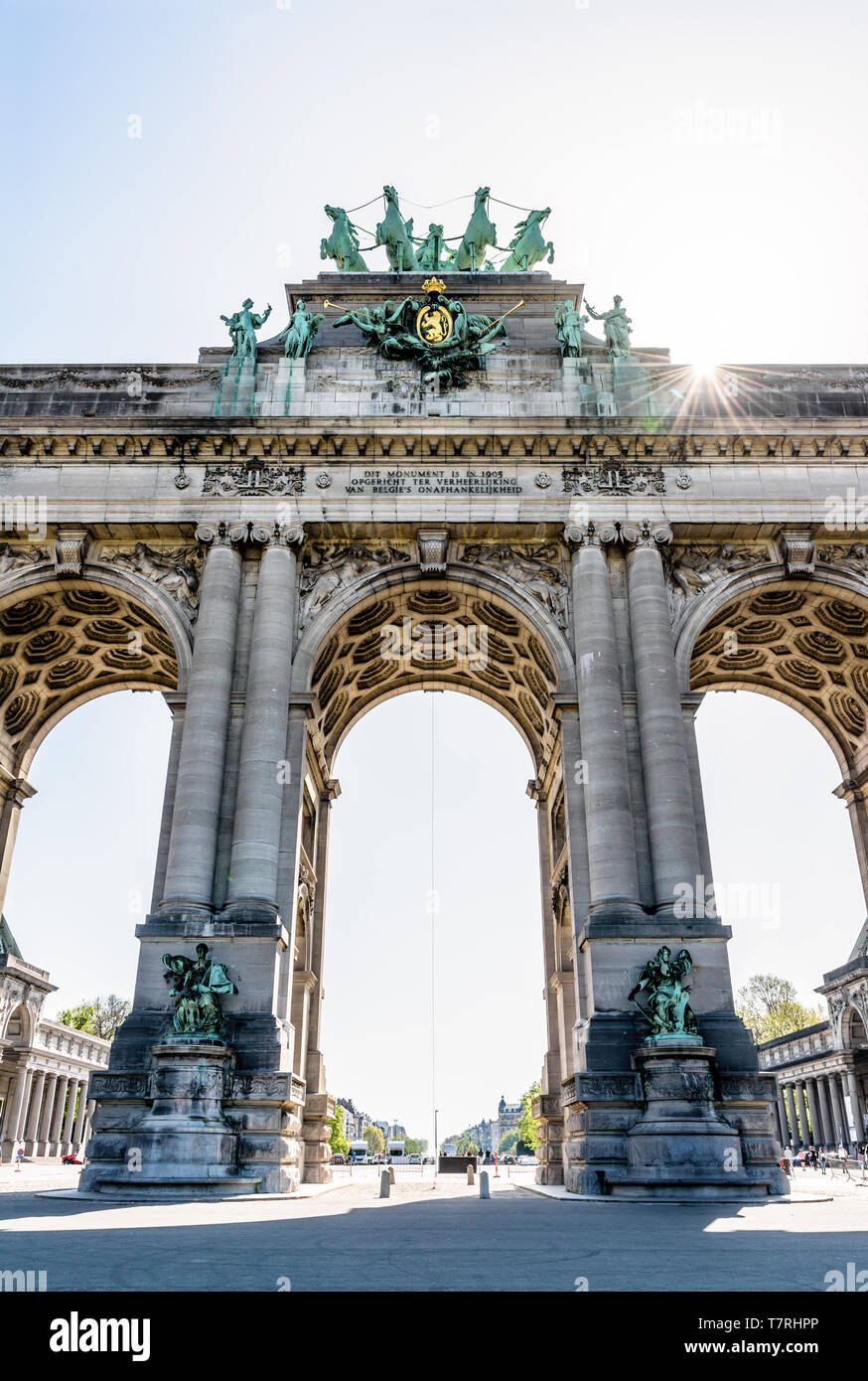 Low angle view of the arcade du Cinquantenaire, l'Arc de triomphe dans le parc du Cinquantenaire à Bruxelles, Belgique, contre les rayons du soleil. Banque D'Images