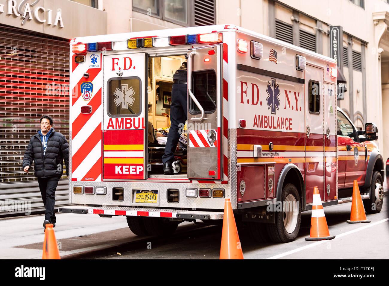 New York - 6 Avril 2018 : NYC midtown avec FDNY ambulance camion rouge ouvert avec une personne sur un brancard stationné sur la rue Banque D'Images