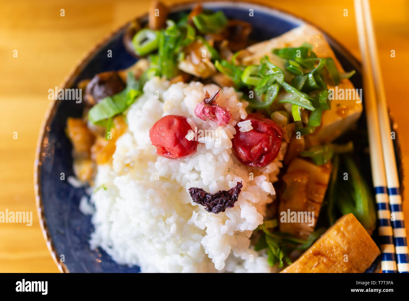 La plaque plat japonais traditionnel au restaurant avec table en bois et de légumes avec du tofu et umeboshi shiso, avec l'oignon vert negi et baguettes Banque D'Images