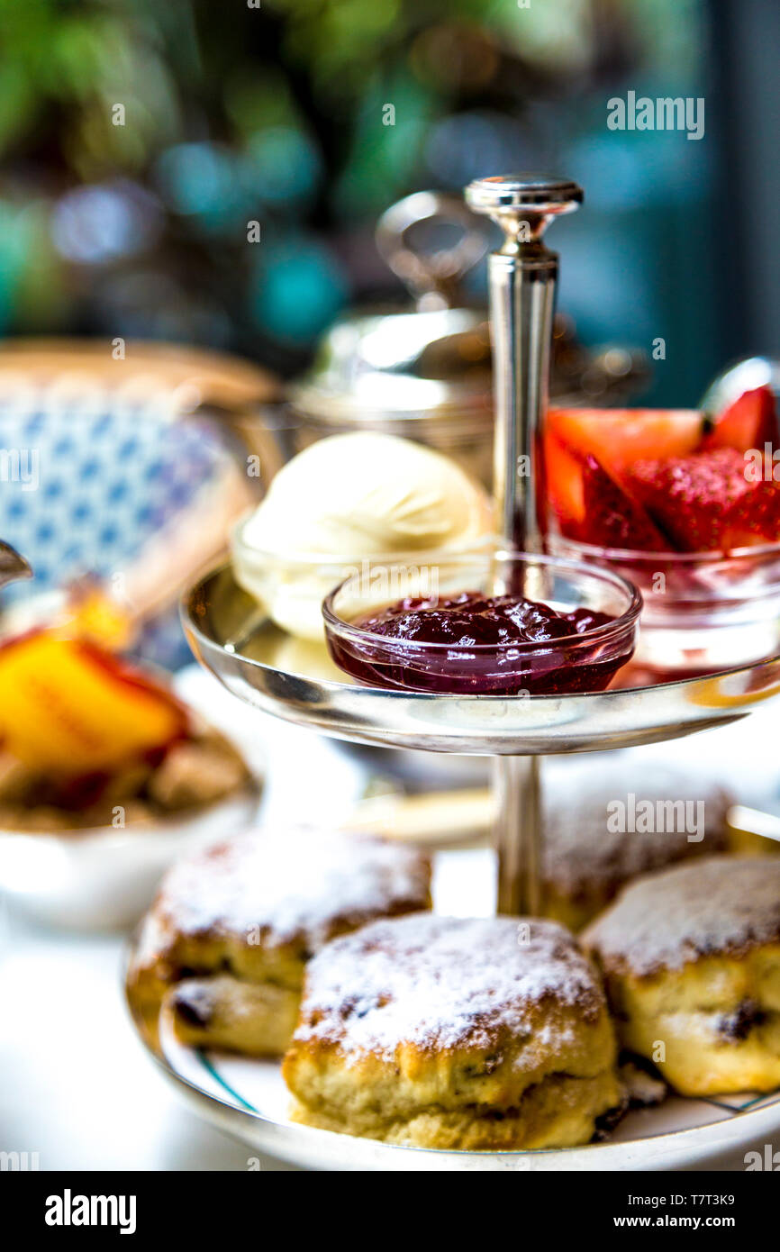 Scones, confiture et crème caillée sur un plateau à plusieurs niveaux, le thé l'après-midi à puce dans le parc à Canary Wharf, London, UK Banque D'Images