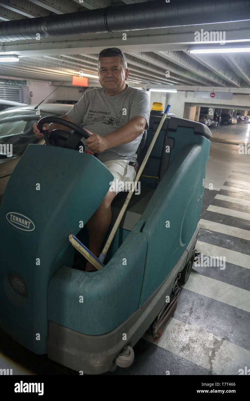 Un homme servant un automoteur machine de nettoyage de plancher. Ein Mann, der eine selbstfahrende Bodenreinigungsmaschine bedient. Mężczyzna podłogę myjący. Banque D'Images