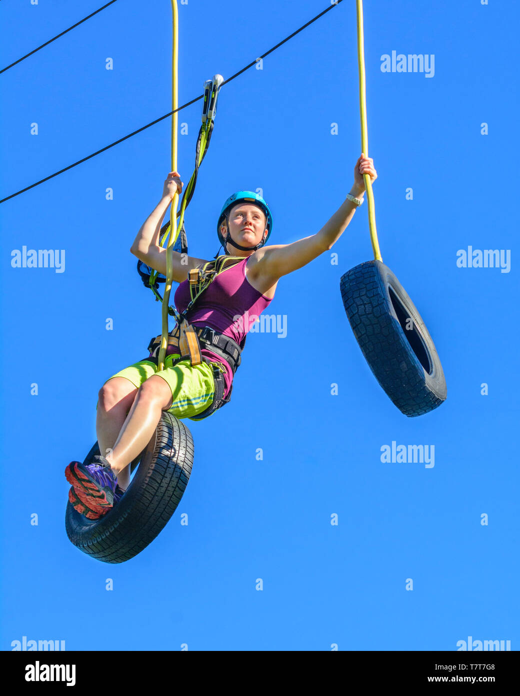 Femme faisant un exercice ardu dans high ropes course Banque D'Images