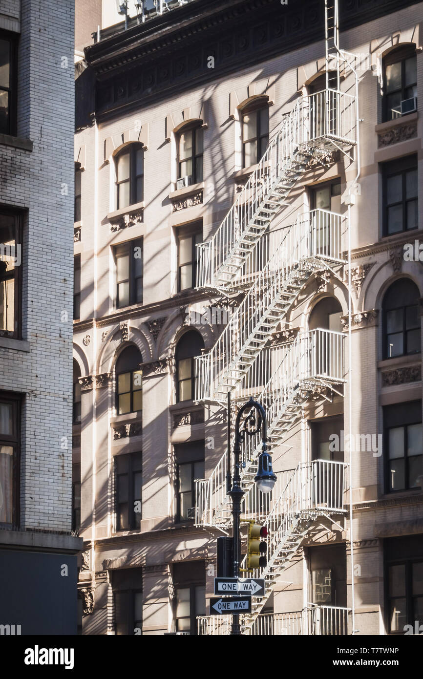 D'une façon ou d'une autre dans les rues de New York, entre les vieux immeubles de la ville et typic feu extérieur s'échappe Banque D'Images