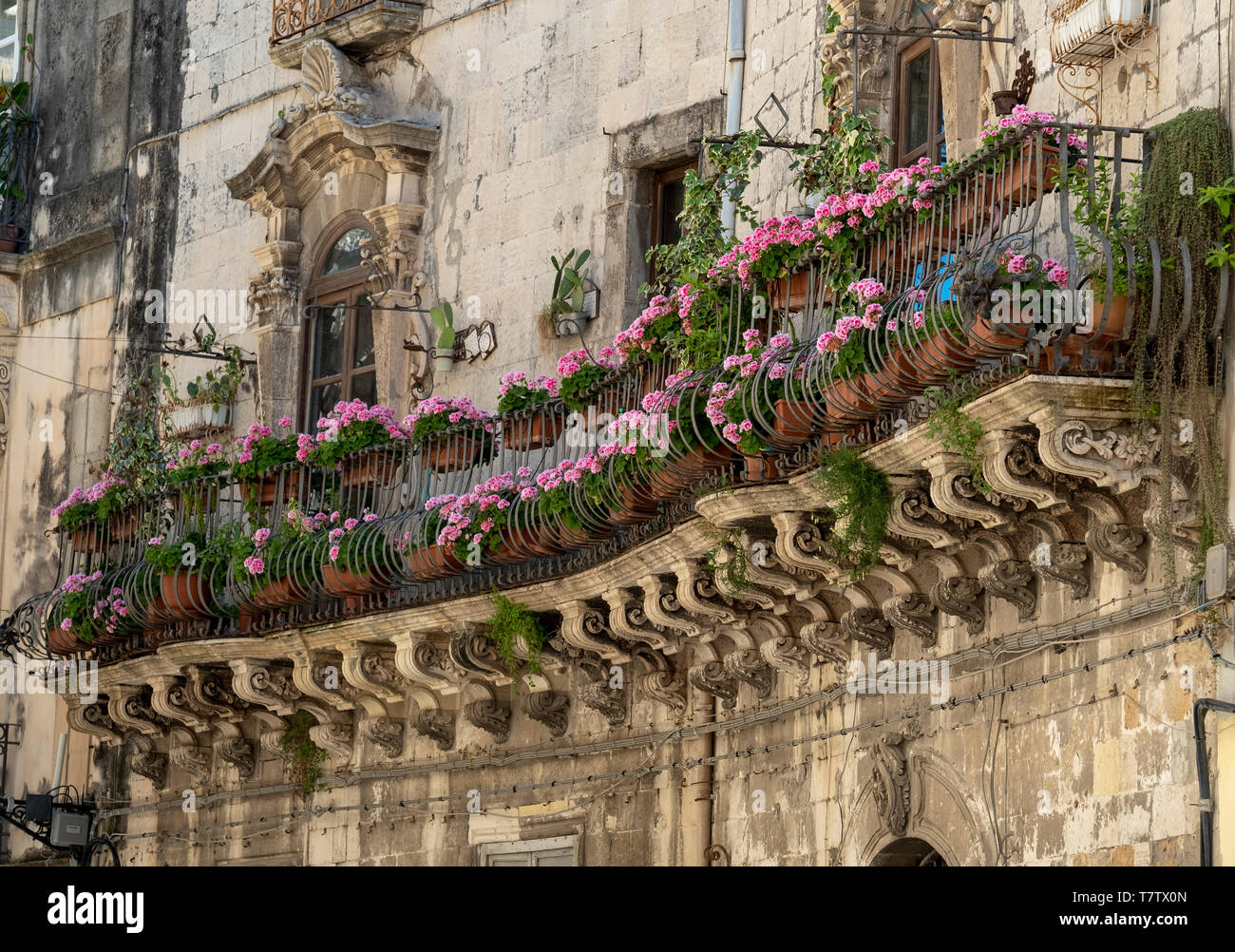 Vieux balcon colorées décorées de fleurs sur l'île de Ortigia, Syracuse, en Sicile. Banque D'Images