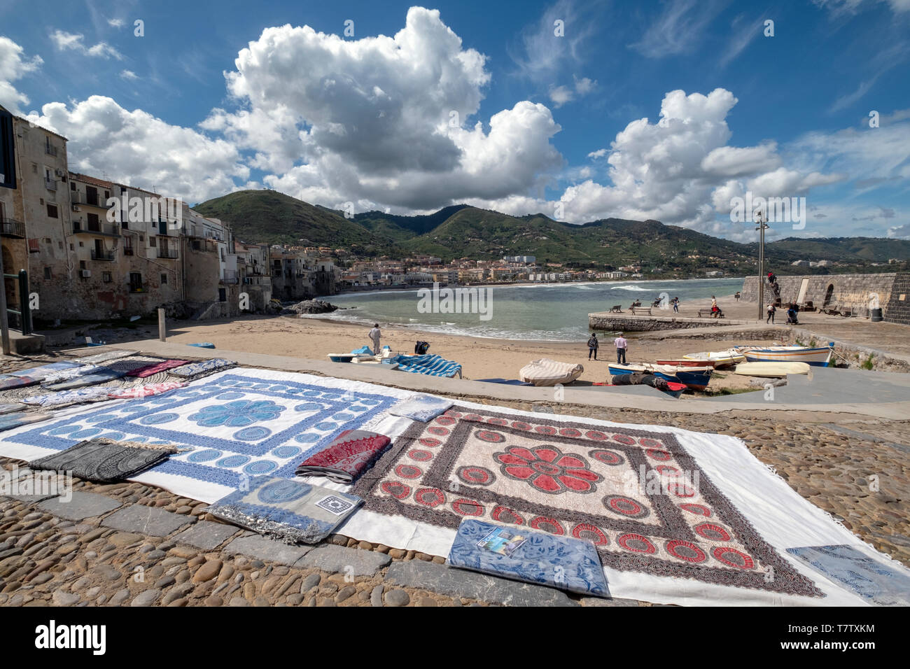 Un tapis ventes de marchandises, et ce, sur la plage, à Cefalu, en Sicile. Banque D'Images
