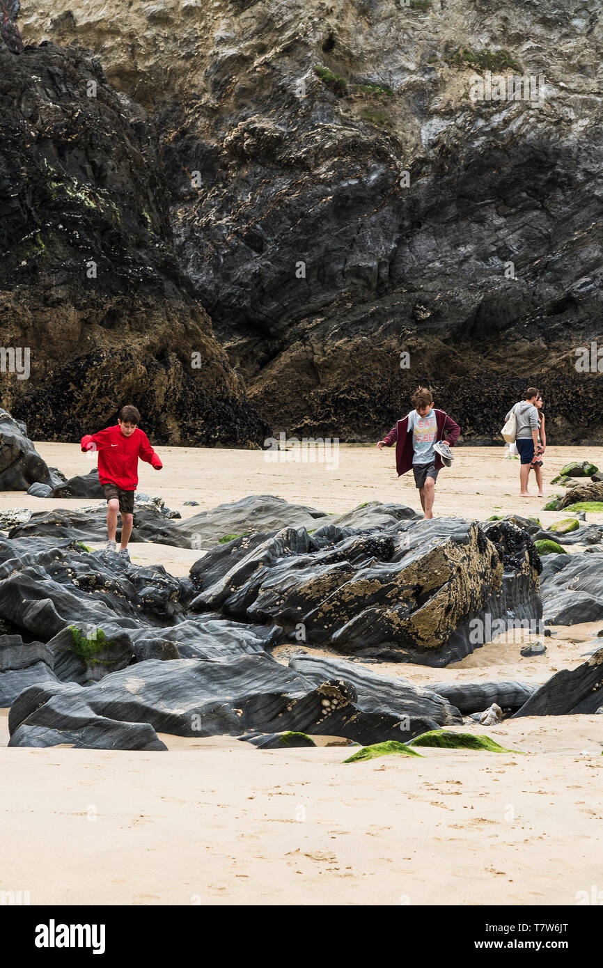 Les jeunes vacanciers à la découverte des rochers à marée basse sur la plage de Towan à Newquay en Cornouailles. Banque D'Images