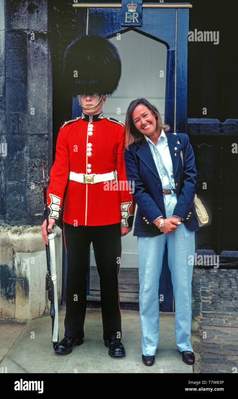 Un imprimeur de la Garde côtière canadienne dans la traditionnelle tunique  rouge et noir bearskin hat conserve son calme comme un touriste femelle  s'étire jusqu'à lui pour une photo souvenir devant sa