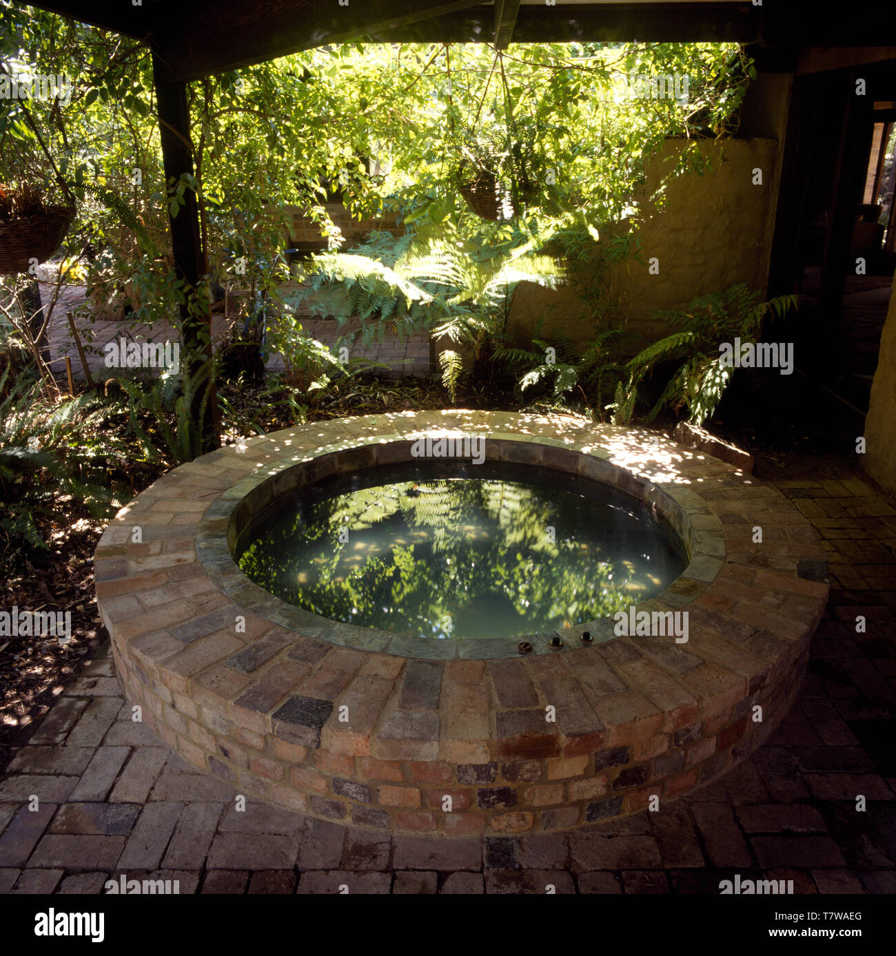 Grumes de brique posée sur la piscine, patio circulaire dans un jardin naturel Banque D'Images