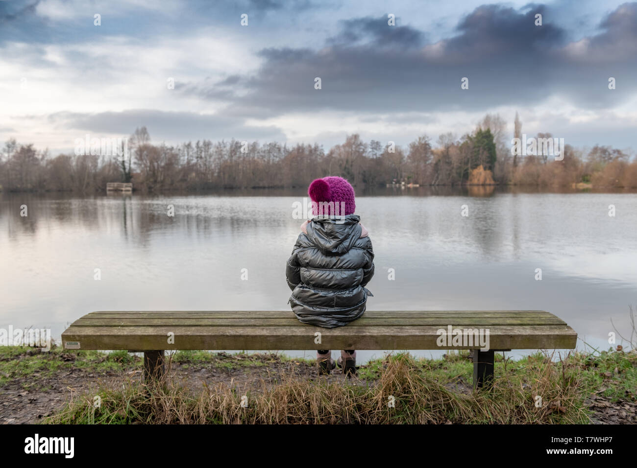 Fille assise au bord d'un lac, France, Pas de Calais, Ardres Banque D'Images