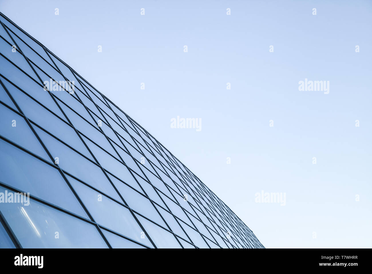 Résumé L'architecture commercial moderne, fragment de mur fait d'acier et de verre sous ciel bleu brillant Banque D'Images