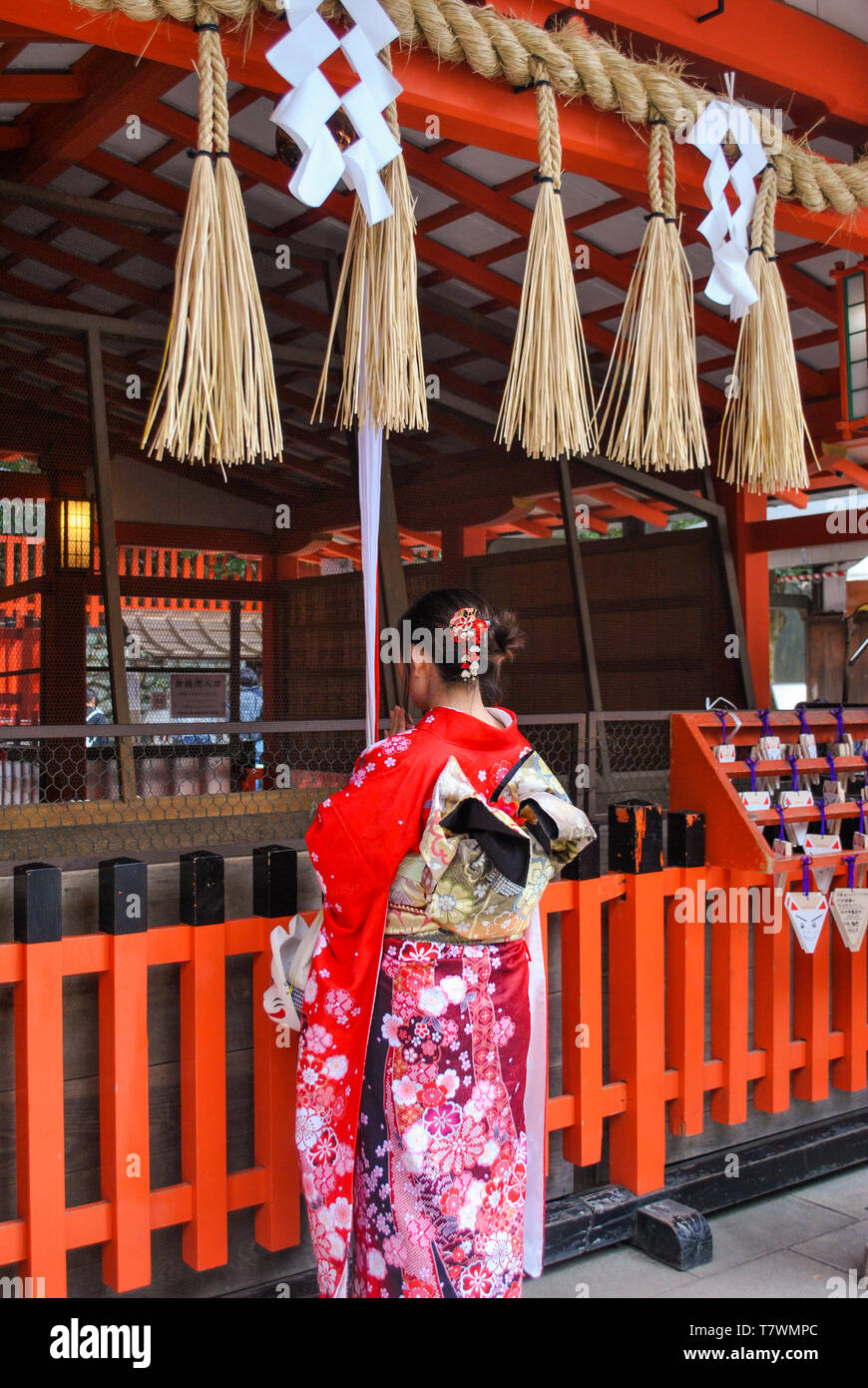 Girl prier dans le sanctuaire Fushimi Inari. Le protocole de Kyoto. Le Japon. Banque D'Images