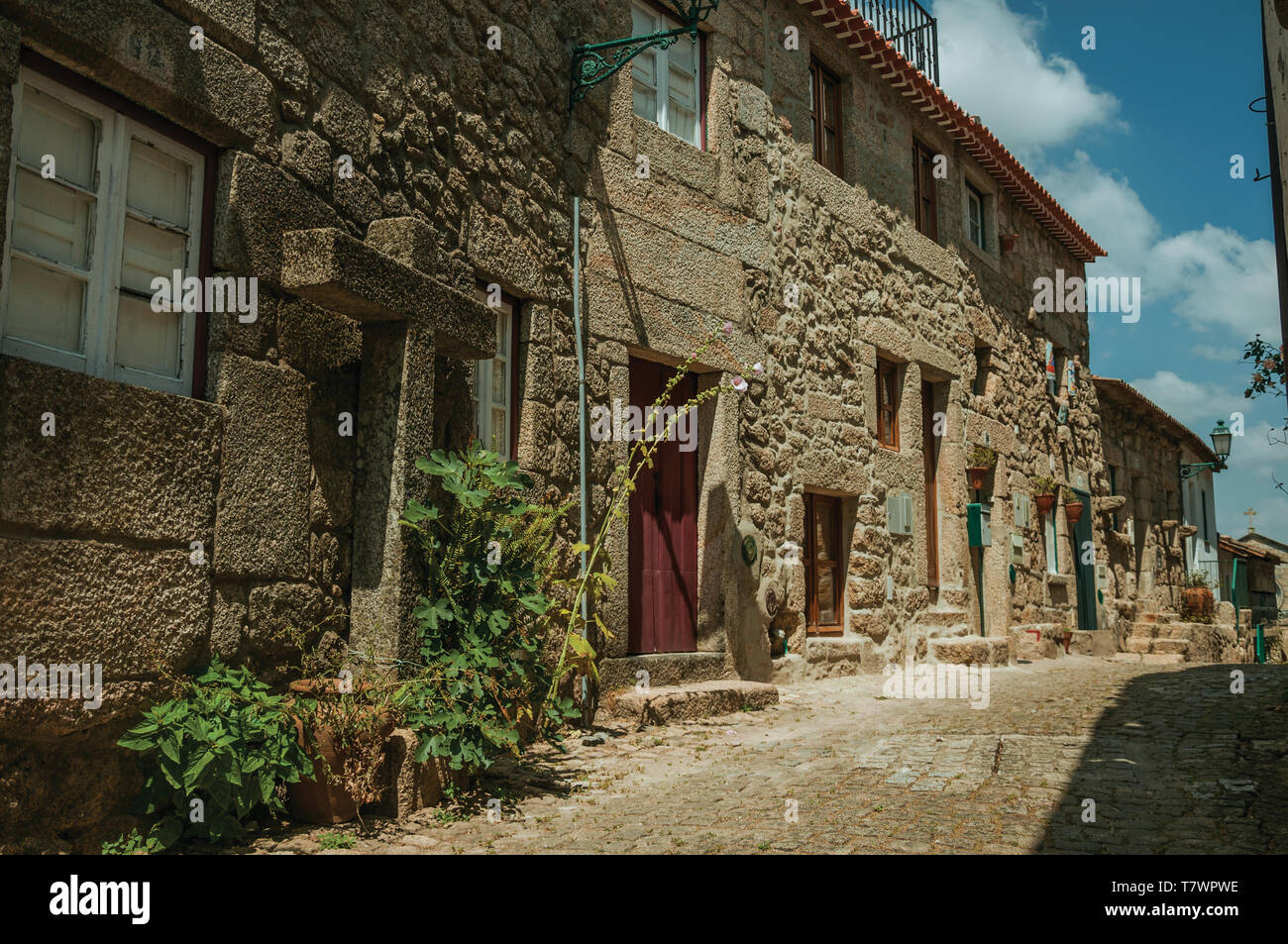 Charmante façade de maisons anciennes aux murs faits de pierre et les portes en bois sur l'allée déserte de Monsanto. Un mignon et curieux village historique du Portugal. Banque D'Images
