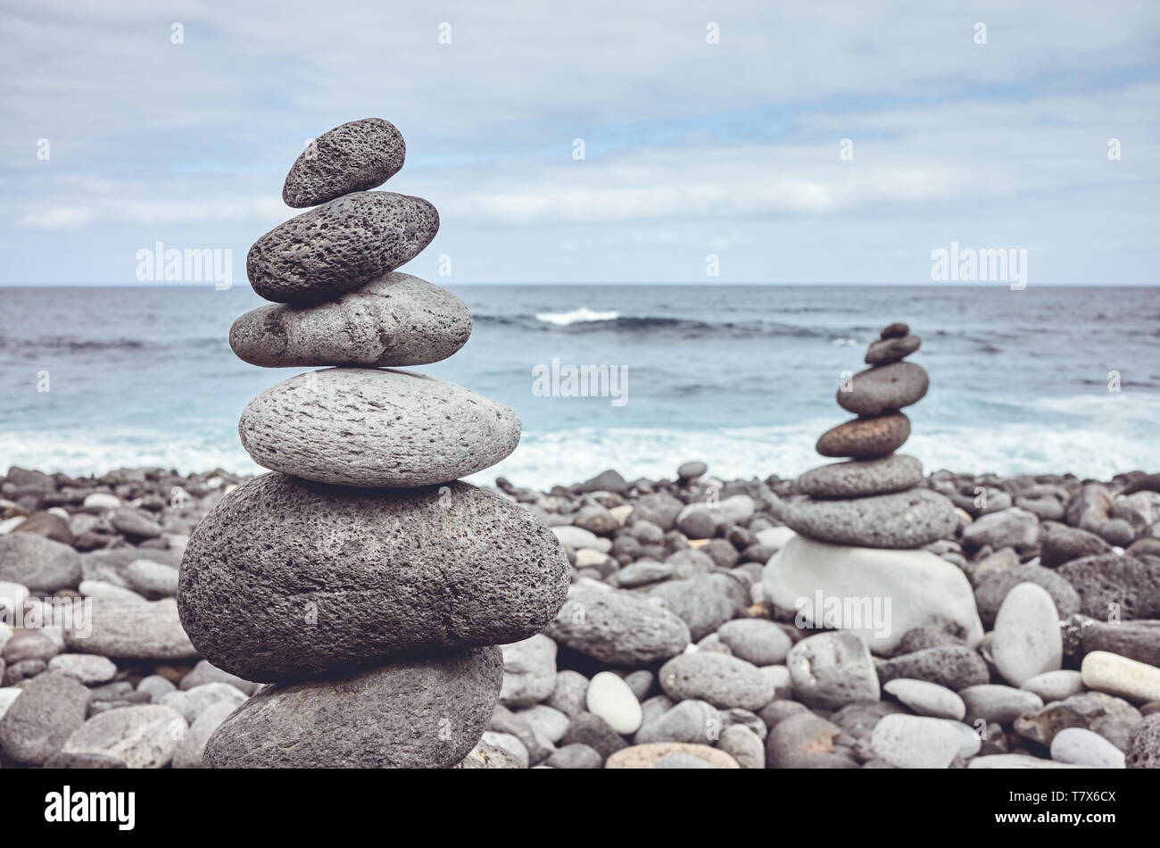 Pyramides faites de pierres sur une plage, dans des tons de couleur photo. Banque D'Images