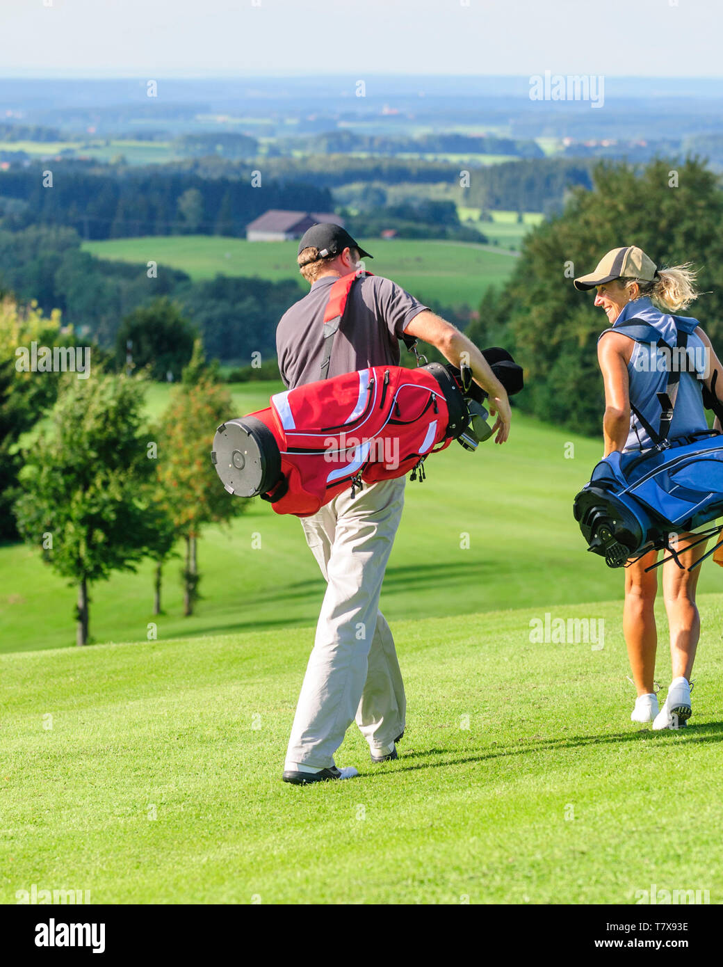 Couple playing golf, sur la voie sur fairway Banque D'Images