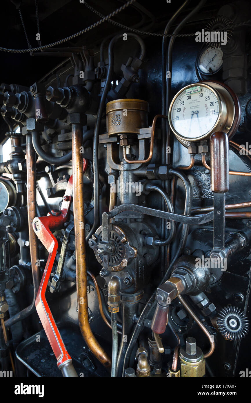 Sur le marchepied d'une locomotive à vapeur britannique vintage : portrait des commandes de travail et des leviers à l'intérieur de la cabine du conducteur du moteur. Banque D'Images