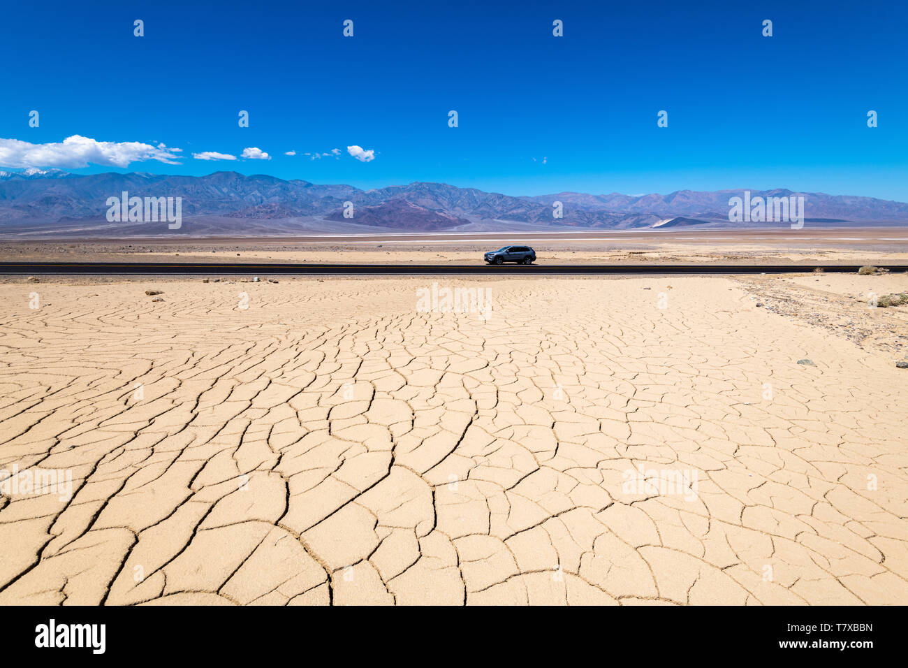 Paysage de la Death Valley National Park, California, USA. Terre craquelée à cause de le soleil et de voiture sur la route *** *** légende locale Banque D'Images