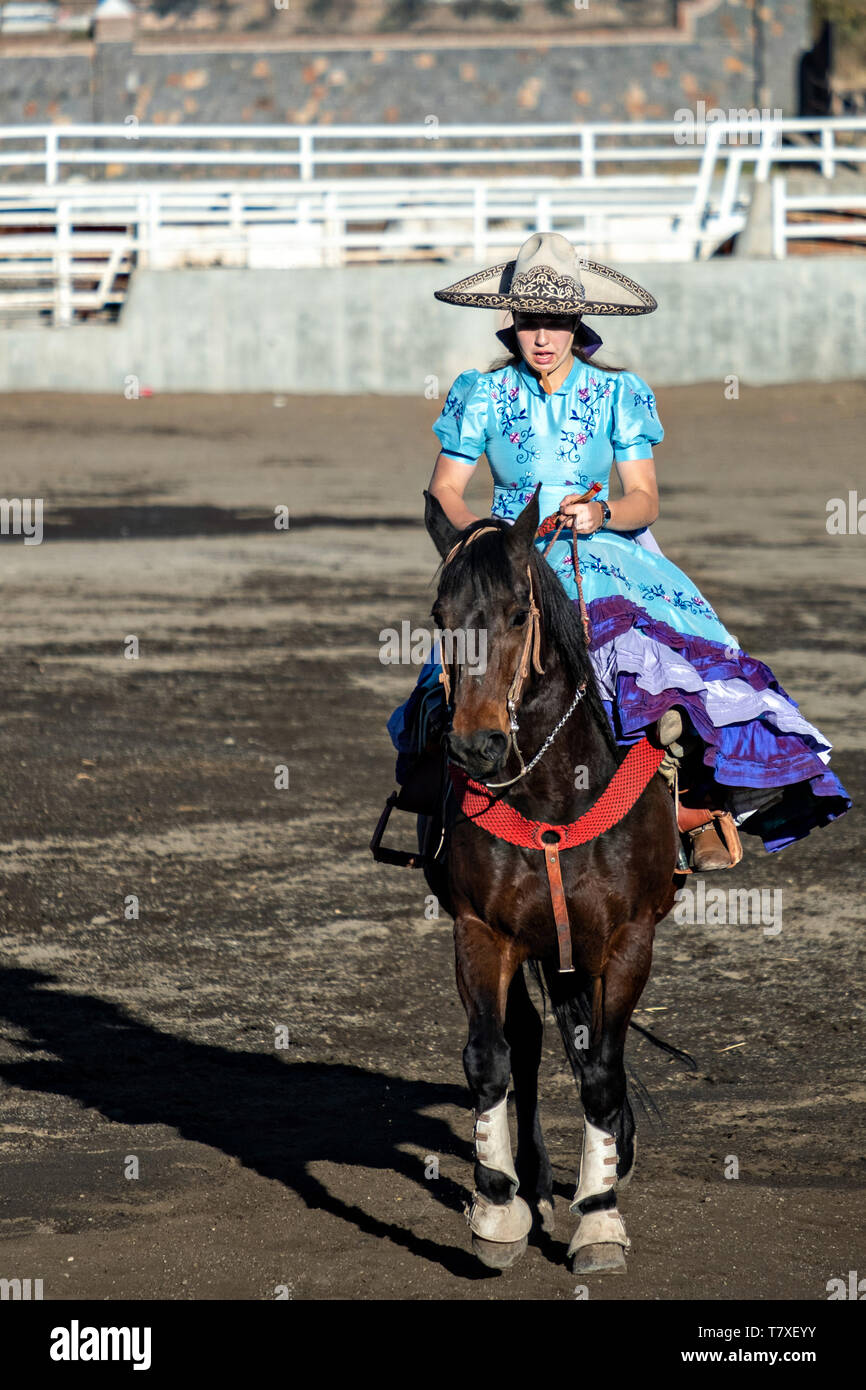 Saray Franco avec le légendaire Franco famille de champions Charro, prend part à la Cala de Caballo amazone dans la traditionnelle robe Adelita lors d'une session pratique rodéo mexicain de Jalisco dans la ville de Highlands Capilla de Guadalupe, au Mexique. Les participantes à l'Escaramuza Charreada traditionnels sont appelés et effectuer la precision des manifestations équestres amazone et vêtue en robe Adelita. Banque D'Images