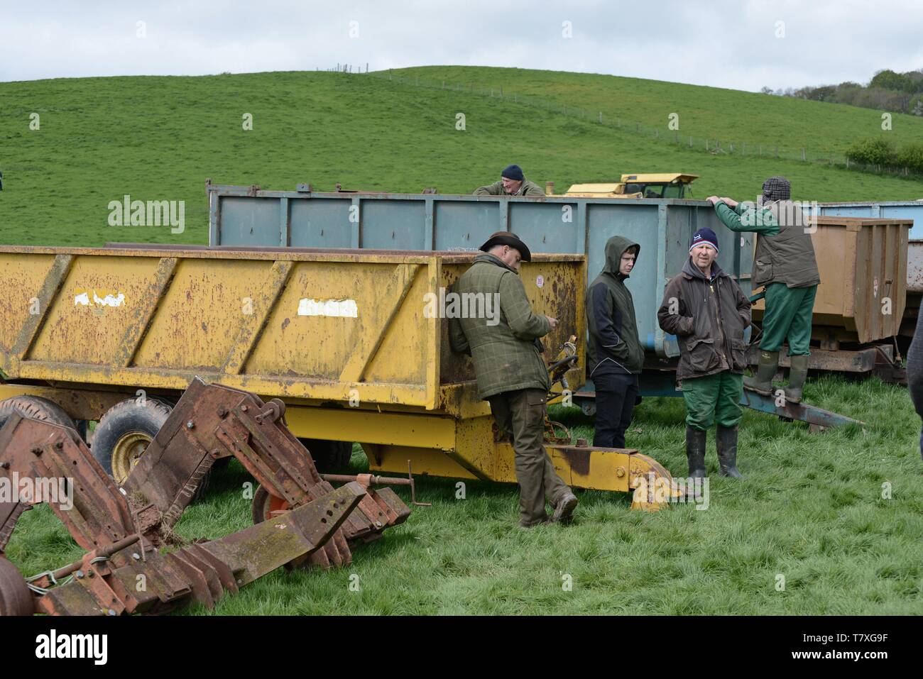 Personnes examinant les tracteurs et machines agricoles vintage à la vente à la ferme vente aux enchères, la Ferme de Venn, Herefordshire Banque D'Images