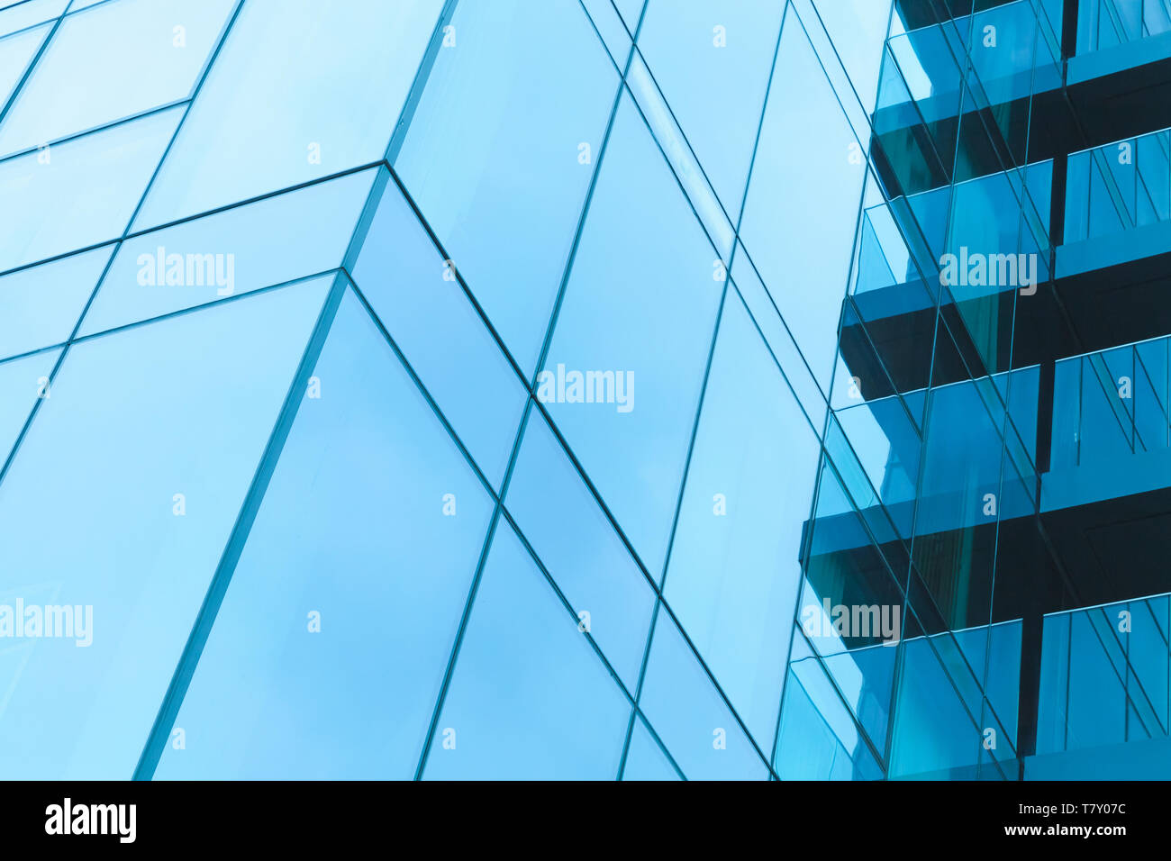 Résumé de l'architecture moderne, de fragments des parois en acier et verre bleu ciel brillant avec reflets. Photo effet filtre tonal bleu Banque D'Images
