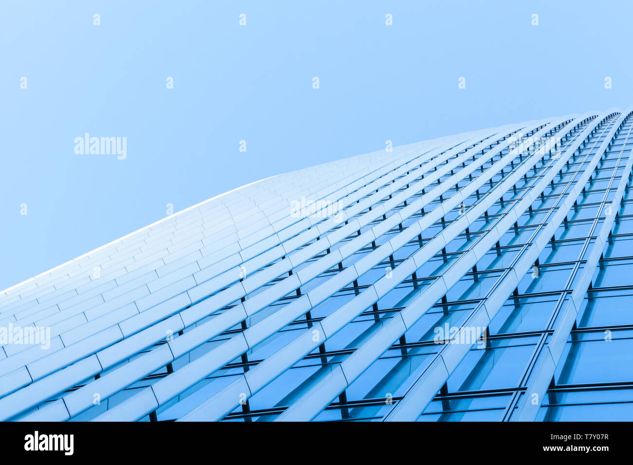 Résumé L'architecture commerciale, fragment de mur fait de métal et de verre sous ciel bleu brillant Banque D'Images