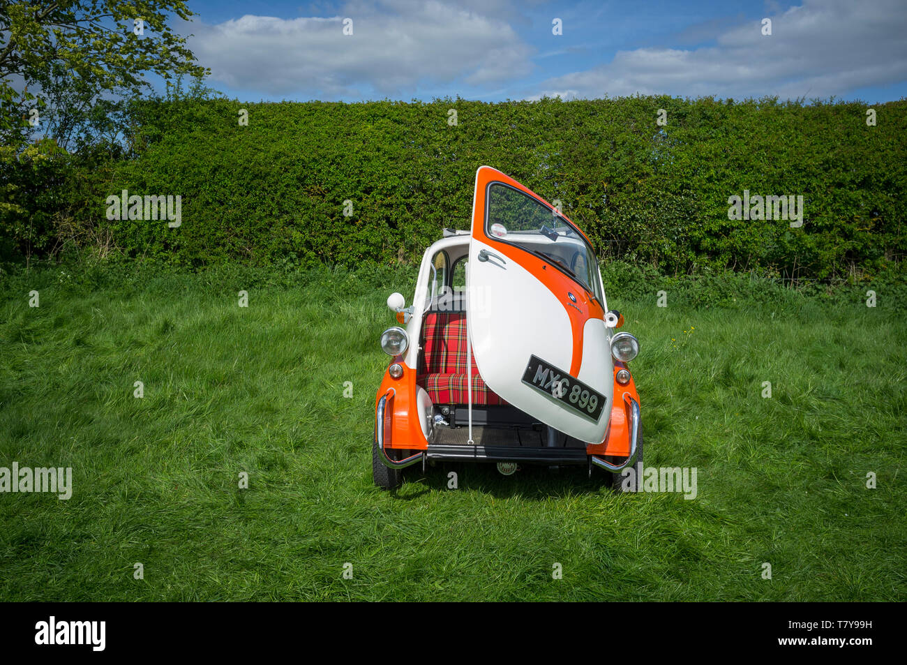 Une orange et blanc classique à deux tons bulle BMW Isetta voiture avec la seule partie porte avant ouverte. Banque D'Images