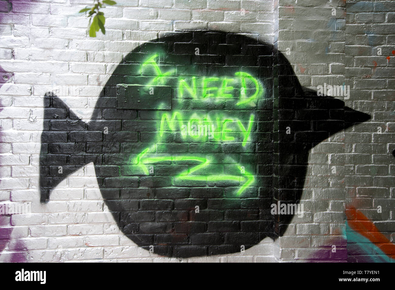 D'Hackney Wick. L'écriture sur le mur , 'j'ai besoin d'argent', à côté du canal. Banque D'Images