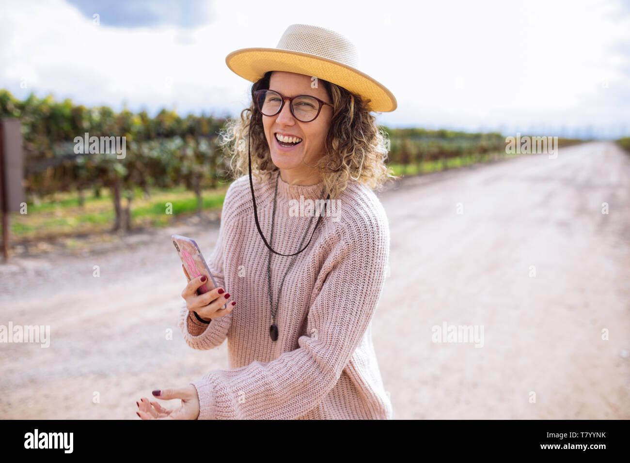 Femme prise d'une photo ou avec un chapeau selfies parmi la vigne dans la région de Bodega Septima Winery, Agrelo, Lujan de Cuyo, Mendoza, Argentine Banque D'Images