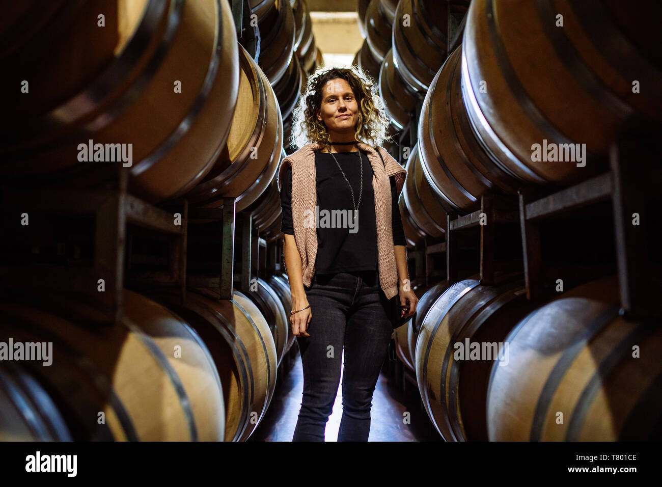 Femme de race blanche dans un milieu de barriques rangées dans Bodega Septima, Agrelo, Lujan de Cuyo, Mendoza, Argentine Banque D'Images