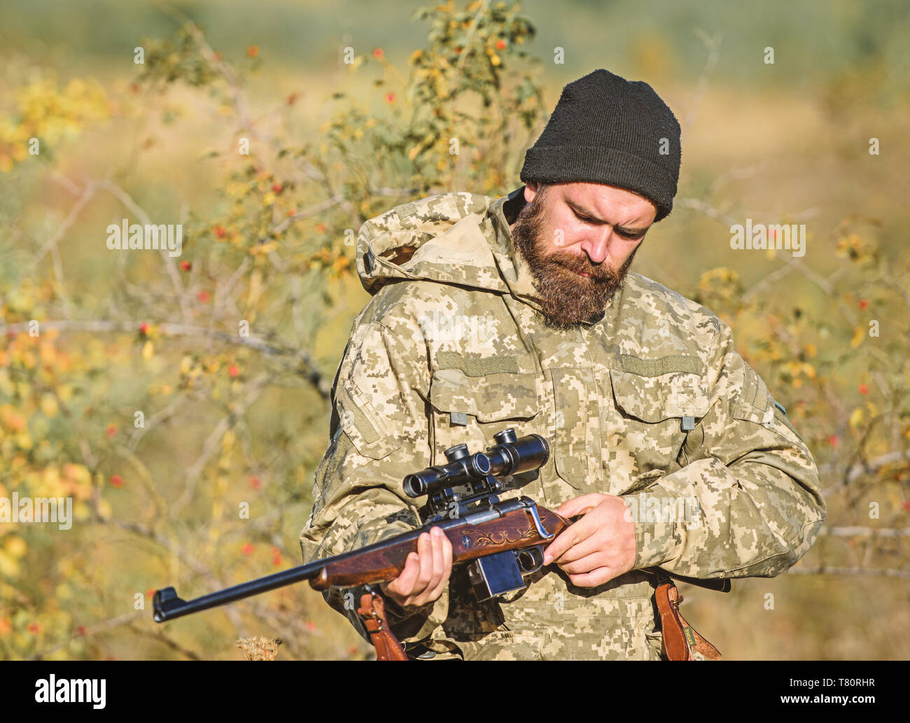 Man hunter avec canon de fusil. Boot Camp. Homme barbu Hunter. Les forces de l'armée. Camouflage. L'uniforme militaire. Les techniques de chasse et d'armes de l'équipement. Comment transformer la chasse en passe-temps. Cowboy avec arme à feu. Banque D'Images