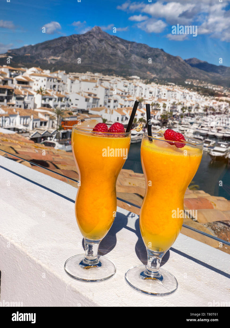 Puerto Banús Marbella espagnol frais jus d'orange naturel verres, sur le luxe en plein air bar terrasse de l'hôtel avec vue sur port de plaisance Puerto Banús Marbella espagne Banque D'Images