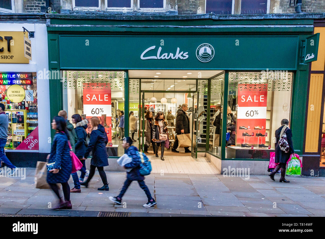 En passant devant les acheteurs à l'extérieur d'un magasin de chaussures Clarks sur une rue animée d'Oxford, au Royaume-Uni. En décembre 2018. Banque D'Images