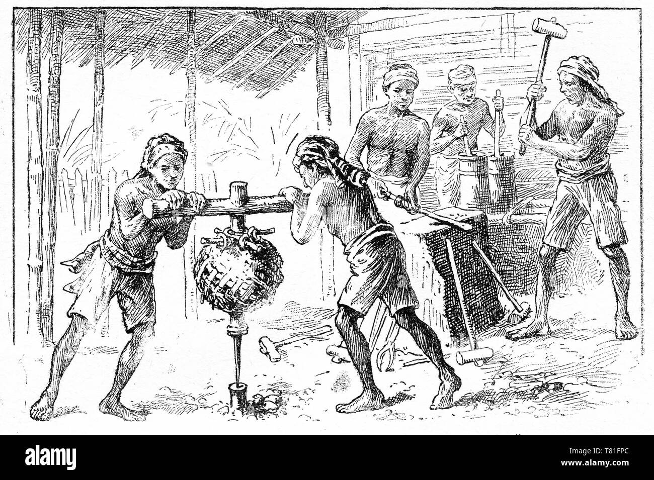 Gravure d'un travailleurs asiatiques dans un atelier du forgeron travaillant à une enclume. Deux garçons se tournent une perceuse pour faire pondérée primitive un trou dans un morceau de métal. Chatterbox Magazine, 1917 Banque D'Images
