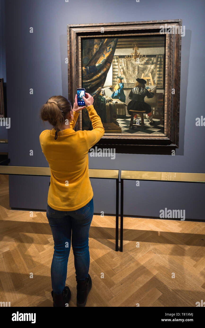 Vue arrière d'une jeune femme prenant une photo de l'Art de la peinture de Jan Vermeer à l'intérieur du Kunsthistorisches Museum de Vienne, en Autriche. Banque D'Images