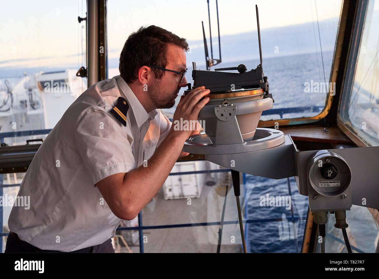 La France, de l'Océan Indien, Finland, Marion Dufresne II (navire d'approvisionnement des TAAF) au pont, Alexandre LE BOUCHER (Lieutenant commissaire) fait une vue du soleil à l'alidade. La position du soleil, il est possible de vérifier le point du GPS Banque D'Images